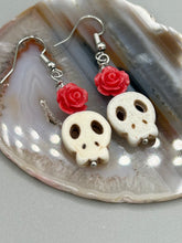 Load image into Gallery viewer, These stylish skull earrings are perfect for adding a unique flair to any outfit. Whether you're looking for a Dia De Los Muertos accessory or simply looking to draw inspiration, these goth pieces perfectly capture the vampire goth, witchy, dark, Chingona Cabrona, Latina Chicana styles. Crafted with Howlite stone skull beads and pink coral quartzize floral beaded earrings, this jewelry set is a unique stunning statement piece.  Measurements: 1 1/4 ” in length