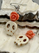Load image into Gallery viewer, These stylish skull earrings are perfect for adding a unique flair to any outfit. Whether you're looking for a Dia De Los Muertos accessory or simply looking to draw inspiration, these goth pieces perfectly capture the vampire goth, witchy, dark, Chingona Cabrona, Latina Chicana styles. Crafted with Howlite stone skull beads and peachy coral quartzize floral beaded earrings, this jewelry set is a unique stunning statement piece.  Measurements: 1 1/4 ” in length