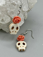 Load image into Gallery viewer, These stylish skull earrings are perfect for adding a unique flair to any outfit. Whether you're looking for a Dia De Los Muertos accessory or simply looking to draw inspiration, these goth pieces perfectly capture the vampire goth, witchy, dark, Chingona Cabrona, Latina Chicana styles. Crafted with Howlite stone skull beads and peachy coral quartzize floral beaded earrings, this jewelry set is a unique stunning statement piece.  Measurements: 1 1/4 ” in length