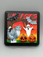 Load image into Gallery viewer, This handcrafted Halloween theme polymer clay wall art boasts a square-shaped wood frame with hand sculpted gray tabby cat, gray and black bats, jack-o-lantern and ghost motifs. Its warm sky hues, including yellow, to orange to dark red are further complemented by the black frame adding an extra layer of sophistication to the spooky warm-toned artwork.  Measurements: H 4" x W 4” x D 1 1/2"
