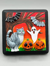 Load image into Gallery viewer, This handcrafted Halloween theme polymer clay wall art boasts a square-shaped wood frame with hand sculpted gray tabby cat, gray and black bats, jack-o-lantern and ghost motifs. Its warm sky hues, including yellow, to orange to dark red are further complemented by the black frame adding an extra layer of sophistication to the spooky warm-toned artwork.  Measurements: H 4" x W 4” x D 1 1/2"
