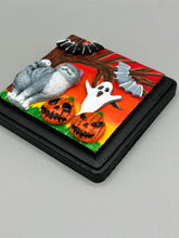 Load image into Gallery viewer, This handcrafted Halloween theme polymer clay wall art boasts a square-shaped wood frame with hand sculpted gray tabby cat, gray and black bats, jack-o-lantern and ghost motifs. Its warm sky hues, including yellow, to orange to dark red are further complemented by the black frame adding an extra layer of sophistication to the spooky warm-toned artwork.  Measurements: H 4" x W 4” x D 1 1/2"