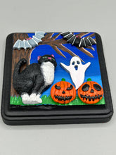 Load image into Gallery viewer, This handcrafted Halloween theme polymer clay wall art boasts a square-shaped wood frame with hand sculpted tuxedo cat, gray and black bats, jack-o-lantern and ghost motifs. Its cool sky hues, including light to dark blues are further complemented by the black frame adding an extra layer of sophistication to the spooky cool-toned artwork.  Measurements: H 4" x W 4” x D 1 1/2"