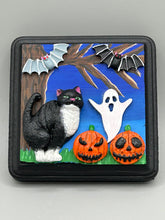 Load image into Gallery viewer, This handcrafted Halloween theme polymer clay wall art boasts a square-shaped wood frame with hand sculpted tuxedo cat, gray and black bats, jack-o-lantern and ghost motifs. Its cool sky hues, including light to dark blues are further complemented by the black frame adding an extra layer of sophistication to the spooky cool-toned artwork.  Measurements: H 4" x W 4” x D 1 1/2"