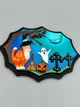 Load image into Gallery viewer, This captivating starry night orange tabby kitty paying a visit to the cemetery is artfully crafted with a black wood frame and a dark blue hues for an eye-catching captivating nocturnal effect art piece. The orange tabby, dressed in a witch's hat, pays a visit to the cemetery accompanied by a broom and a jack-o-lantern. This bewitching and whimsical Halloween-themed art piece adds a one-of-a-kind Halloween touch to any home or office. Measurements: H 5" x W 7” x D 1 1/2"