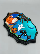 Load image into Gallery viewer, This captivating starry night orange tabby kitty paying a visit to the cemetery is artfully crafted with a black wood frame and a dark blue hues for an eye-catching captivating nocturnal effect art piece. The orange tabby, dressed in a witch's hat, pays a visit to the cemetery accompanied by a broom and a jack-o-lantern. This bewitching and whimsical Halloween-themed art piece adds a one-of-a-kind Halloween touch to any home or office. Measurements: H 5" x W 7” x D 1 1/2"