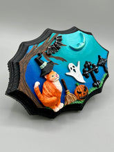 Load image into Gallery viewer, This captivating starry night orange tabby kitty paying a visit to the cemetery is artfully crafted with a black wood frame and a dark blue hues for an eye-catching captivating nocturnal effect art piece. The orange tabby, dressed in a witch's hat, pays a visit to the cemetery accompanied by a broom and a jack-o-lantern. This bewitching and whimsical Halloween-themed art piece adds a one-of-a-kind Halloween touch to any home or office. Measurements: H 5" x W 7” x D 1 1/2"