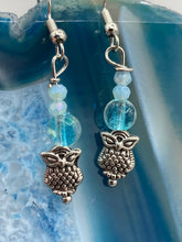 Load image into Gallery viewer, Beautiful delicate glass beaded earrings featuring silver-plated night owl charms in an enchanting pale blue hue. Measurements: 1 1/4” in length