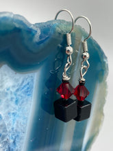 Load image into Gallery viewer, This eye-catching piece features two unconventional components: a large square-shaped black obsidian bead and a large, dark red glass bead. With the beautiful interplay of colors and shapes, these earrings are truly unique, yet at the same time, versatile enough to be paired with a range of styles.  Measurements: 1” in length