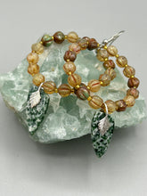 Load image into Gallery viewer, Green-White Qinghai Green Jasper Stone Beaded Hoop Earrings provide a nature-inspired look that is perfect for any boho-chic style. These earrings feature natural green jasper stone triangle pendant with champagne mix melon Czech faceted round glass beads. Glass beads have a tint of light champagne, amber, dark green and gold shimmer for subtle accent. Show off your bohemian look with these eye-catching hoops. Antique Copper Plated Surgical Steel Hammered Long Ear-wire French Hook Earrings.