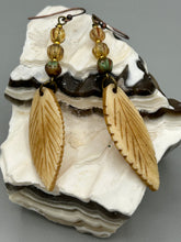 Load image into Gallery viewer, Single-stranded earring features bone carved leaf charm earrings with champagne mix melon Czech faceted round glass beads.  Glass beads have a tint of light champagne, amber, dark green and gold shimmer. Antique Copper Plated Surgical Steel Hammered Long Ear-wire French Hook Earrings.   Measurements: 3” in length
