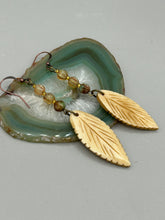 Load image into Gallery viewer, Single-stranded earring features bone carved leaf charm earrings with champagne mix melon Czech faceted round glass beads.  Glass beads have a tint of light champagne, amber, dark green and gold shimmer. Antique Copper Plated Surgical Steel Hammered Long Ear-wire French Hook Earrings.   Measurements: 3” in length