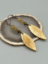 Load image into Gallery viewer, Single-stranded earring features bone carved leaf charm earrings with champagne mix melon Czech faceted round glass beads.  Glass beads have a tint of light champagne, amber, dark green and gold shimmer. Antique Copper Plated Surgical Steel Hammered Long Ear-wire French Hook Earrings.   Measurements: 3” in length