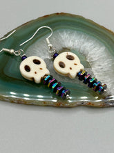 Load image into Gallery viewer, Spooky skull beads come with spine earrings. These stylish skull earrings are perfect for adding a unique flair to any outfit. Whether you're looking for a Dia De Los Muertos accessory or simply looking to draw inspiration, these goth pieces perfectly capture the vampire goth, witchy, dark, Chingona Cabrona, Latina Chicana styles. Measurements: 1 1/4” in length