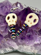 Load image into Gallery viewer, Spooky skull beads come with spine earrings. These stylish skull earrings are perfect for adding a unique flair to any outfit. Whether you're looking for a Dia De Los Muertos accessory or simply looking to draw inspiration, these goth pieces perfectly capture the vampire goth, witchy, dark, Chingona Cabrona, Latina Chicana styles. Measurements: 1 1/4” in length