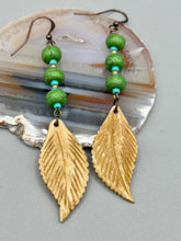 Load image into Gallery viewer, Single-stranded earring features bone carved leaf charm earrings with bright green magnesite stone and blue turquoise and gold glass beads. Antique Copper Plated Surgical Steel Hammered Long Ear-wire French Hook Earrings. Measurements: 3” in length