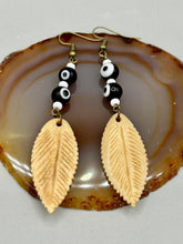 Load image into Gallery viewer, Single-stranded earring features bone carved leaf charm earrings with black and white eye-dot glass beads. Antique Copper Plated Surgical Steel Hammered Long Ear-wire French Hook Earrings.  Measurements: 3” in length