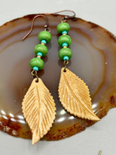 Load image into Gallery viewer, Single-stranded earring features bone carved leaf charm earrings with bright green magnesite stone and blue turquoise and gold glass beads. Antique Copper Plated Surgical Steel Hammered Long Ear-wire French Hook Earrings. Measurements: 3” in length