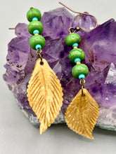 Load image into Gallery viewer, Single-stranded earring features bone carved leaf charm earrings with bright green magnesite stone and blue turquoise and gold glass beads. Antique Copper Plated Surgical Steel Hammered Long Ear-wire French Hook Earrings. Measurements: 3” in length