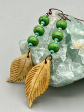 Load image into Gallery viewer, Single-stranded earring features bone carved leaf charm earrings with bright green magnesite stone and blue turquoise and gold glass beads. Antique Copper Plated Surgical Steel Hammered Long Ear-wire French Hook Earrings. Measurements: 3” in length