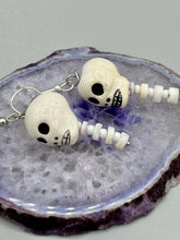 Load image into Gallery viewer, Peruvian off white ceramic skull beads come with spine earrings. These stylish skull earrings are perfect for adding a unique flair to any outfit. Whether you're looking for a Dia De Los Muertos accessory or simply looking to draw inspiration, these goth pieces perfectly capture the vampire goth, witchy, dark, Chingona Cabrona, Latina Chicana styles. Measurements: 1 1/4” in length