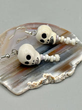 Load image into Gallery viewer, Peruvian off white ceramic skull beads come with spine earrings. These stylish skull earrings are perfect for adding a unique flair to any outfit. Whether you're looking for a Dia De Los Muertos accessory or simply looking to draw inspiration, these goth pieces perfectly capture the vampire goth, witchy, dark, Chingona Cabrona, Latina Chicana styles. Measurements: 1 1/4” in length