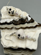 Load image into Gallery viewer, Peruvian off white ceramic skull beads come with spine earrings. These stylish skull earrings are perfect for adding a unique flair to any outfit. Whether you're looking for a Dia De Los Muertos accessory or simply looking to draw inspiration, these goth pieces perfectly capture the vampire goth, witchy, dark, Chingona Cabrona, Latina Chicana styles. Measurements: 1 1/4” in length