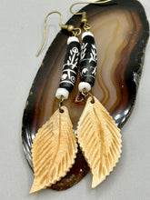 Load image into Gallery viewer, Single-stranded earring features bone carved leaf charm earrings with black and white bone carved floral design beads. Antique brass-plated steel ear-wire French Hook Earrings.   Measurements: 3” in length