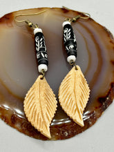 Load image into Gallery viewer, Single-stranded earring features bone carved leaf charm earrings with black and white bone carved floral design beads. Antique brass-plated steel ear-wire French Hook Earrings.   Measurements: 3” in length