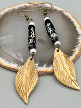 Load image into Gallery viewer, Single-stranded earring features bone carved leaf charm earrings with black and white bone carved floral design beads. Antique brass-plated steel ear-wire French Hook Earrings.   Measurements: 3” in length