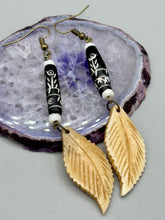Load image into Gallery viewer, Single-stranded earring features bone carved leaf charm earrings with black and white bone carved floral design beads. Antique brass-plated steel ear-wire French Hook Earrings.   Measurements: 3” in length