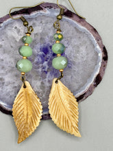 Load image into Gallery viewer, Single-stranded earring features bone carved leaf charm earrings with light mint faceted round glass beads.  Glass beads have a tint of dark green and gold shimmer. Antique antique brass plated steel ear-wire French Hook Earrings.   Measurements: 3” in length