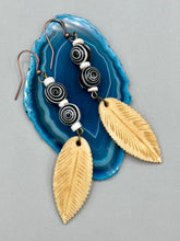 Load image into Gallery viewer, Single-stranded earring features bone carved leaf charm earrings with black and white swirly eye-dot glass beads. Antique Copper Plated Surgical Steel Hammered Long Ear-wire French Hook Earrings. Measurements: 3” in length