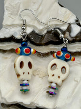 Load image into Gallery viewer, Spooky but festive skull beads with hematite bead spines and come with fiesta shaped crown glass earrings. These stylish skull earrings are perfect for adding a unique flair to any outfit. Whether you're looking for a Dia De Los Muertos accessory or simply looking to draw inspiration, these goth pieces perfectly capture the vampire goth, witchy, dark, Chingona Cabrona, Latina Chicana styles. Measurements: 1 1/2” in length
