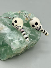 Load image into Gallery viewer, Spooky skull peruvian ceramic beads come with spine earrings. These stylish skull earrings are perfect for adding a unique flair to any outfit. Whether you're looking for a Dia De Los Muertos accessory or simply looking to draw inspiration, these goth pieces perfectly capture the vampire goth, witchy, dark, Chingona Cabrona, Latina Chicana styles. Measurements: 1 1/2” in length