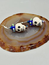Load image into Gallery viewer, Spooky but festive Peruvian ceramic skull beads with hematite beaded spines and come with fiesta shaped crown glass earrings. These stylish skull earrings are perfect for adding a unique flair to any outfit. Whether you're looking for a Dia De Los Muertos accessory or simply looking to draw inspiration, these goth pieces perfectly capture the vampire goth, witchy, dark, Chingona Cabrona, Latina Chicana styles. Measurements: 1 1/4” in length