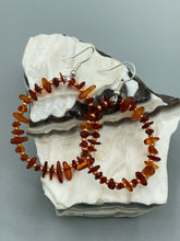 Load image into Gallery viewer, These hoop earrings feature natural amber stone chips and gold glass beads for an elegant, nature-inspired look. Measurements: 2" length and 2” in width