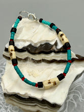 Load image into Gallery viewer, These stylish skull bracelet is perfect for adding a unique flair to any outfit. Whether you're looking for a Dia De Los Muertos accessory or simply looking to draw inspiration, these goth pieces perfectly capture the vampire goth, witchy, dark, Chingona Cabrona, Latina Chicana styles. Skull-shaped bone beads adorned with dark brown, turquoise, and gold beads make up this unique statement piece. Measurements: Bracelet: 7 1/2"