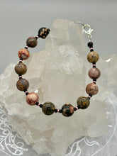 Load image into Gallery viewer, Nature inspired single-strand leopard jasper round stone beads with gold and black glass beaded bracelet. Leopard jasper stone has an array on neutral earth tones including soft pink, salmon, and gray tones. Crafted with metal wire and fastened with a lobster claw clasp. Measurements: Bracelet: 7 1/2" in length
