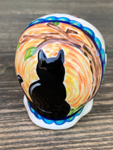 Load image into Gallery viewer, Inspired by nature, ceramic skull is full of vibrant colors and intricate details. The primary color is white with a black cat silhouette and multi-color floral motifs, along with hearts and leaves and lively colorful accents around the entire skull. Mini skull represented the eternal love for a special kitty cat in your life. Black cat silhouette is sitting on a tree branch admiring the starry night sky. Art created for all the cat lovers who adore their sweet kitty. Measurements: H 2 3/4” x W 2” x D 2”