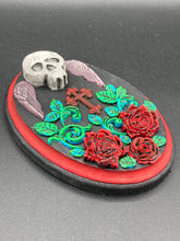 Load image into Gallery viewer, This Memento Mori Wall Art Decor is a one-of-a-kind art piece, skillfully crafted with a black polymer clay skull and wings on a dark red wood frame, decoratively woven with dark red roses and vines. It's perfect for adding an eye-catching touch to any wall and makes a unique, bold gift.  Measurements: H 7" x W 5” x D 1 1/2"