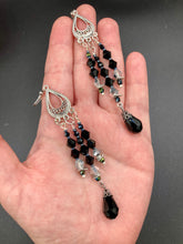 Load image into Gallery viewer, This stylish three-strand black and silver glass beaded earring design presents a beautiful dancing effect, boasting a large black teardrop glass bead. A versatile accessory, it suits a variety of ensembles from cocktail chic to wedding fineries, and its minimalist aesthetic lends a modern charm.  Measurements: 3 3/4” in length