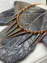 Load image into Gallery viewer, A copper-toned, adjustable Steampunk-style glass beaded necklace is detailed with sharp-drop metal plated hanging beads. Bright orange rectangular tube beads mix with other shapes for an eye-catching effect, while double-hole flat matte copper-toned beads provide a collar finish which makes this piece drape elegantly across the neck. A bold and sophisticated accessory.