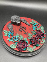 Load image into Gallery viewer, This Memento Mori Wall Art Decor is a one-of-a-kind art piece, skillfully crafted with a black polymer clay skull and wings on a dark red wood frame, decoratively woven with dark red roses and vines. It's perfect for adding an eye-catching touch to any wall and makes a unique, bold gift.  Measurements:  Diameter 6 3/4" x Depth 1 1/2"