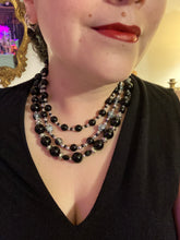 Load image into Gallery viewer, This stunning Shimmery black glass and floral metal beaded necklace features three long strands which gracefully drape around the neck. Its bold elegance is the perfect accessory for a cocktail chic outfit, a wedding, or a more minimalist look.  Measurements:    Necklace is 16 1/4” in length - adjustable to 18"