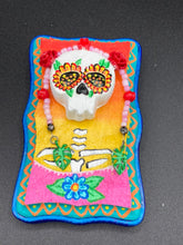 Load image into Gallery viewer, Transform your walls with this handcrafted polymer clay wall art. Showcasing a vibrant Frida Kahlo inspired calavera with hand-beaded floral crown, this Day of the Dead wall decor piece is perfect for adding a traditional Mexican folk art touch to any home.