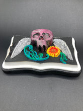 Load image into Gallery viewer, This unique wall art decor, crafted with hand-molded polymere clay and painted on a wooden frame, brings to life a classic Dia De Los Muertos Calavera with its fiery-red skull and bright yellow-orange flower and vine accents. Perfect for accenting your crystal display, witchy altar, or indoor garden.