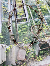 Load image into Gallery viewer, This exquisite necklace features a soft pink Rose Quartz pendant with multi-colored glass beads that transition from iridescent pink, to light purple and darker shades of purple. The sequence of beads complements the Rose Quartz pendant's delicate hue, and is accompanied with a set of subtly-styled matching earrings for a complete look. Measurements: Necklace is 16 1/2”