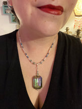 Load image into Gallery viewer, This gorgeous, Bohemian-style necklace features a shimmery aqua blue and gold-toned glass beaded design, with a large, faceted rectangular pendant adding dramatic flair. The vibrant and eye-catching colors make it the perfect way to add a pop of color to any ensemble and the draping style will give you a look that is both bold and elegant. Measurements: Necklace is 17” - adjustable to 18", pendant is 2 1/4”