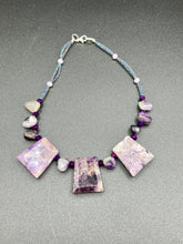 Load image into Gallery viewer, This necklace features large trapezoid-shaped Amethyst pendants and small Amethyst nuggets strung together with shimmery multicolored glass beads, creating a unique and eye-catching statement piece. Measurements: Necklace is is 15 1/2” adjustable up to 17"